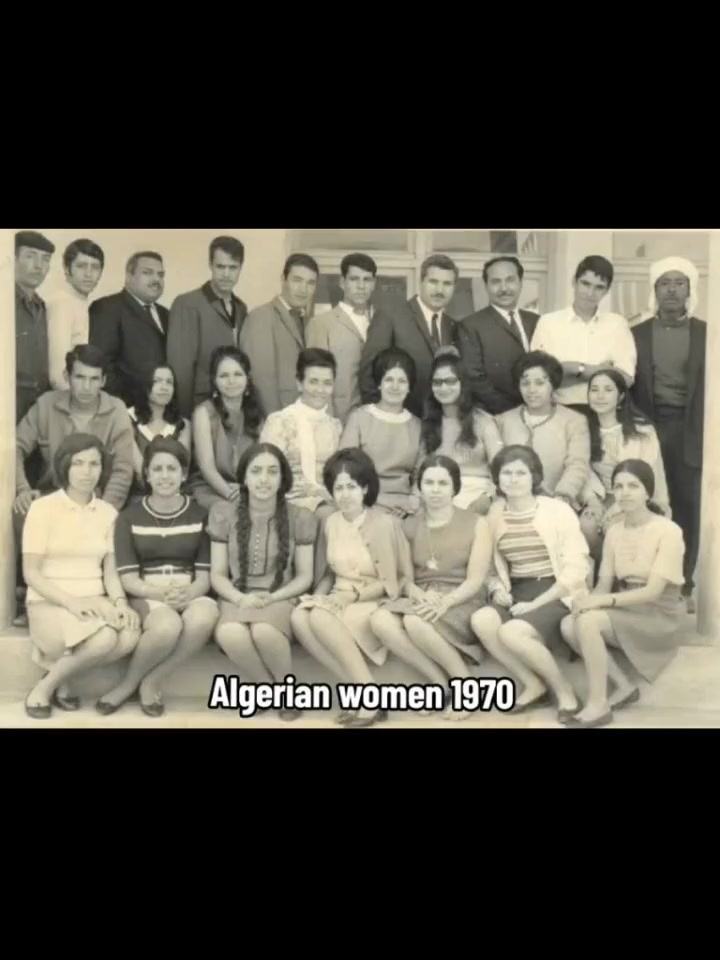 Algerian women and men in a group photo in 1970 — women in short skirts, sleeveless tops, and Western dress, hair visible. A university or school setting.