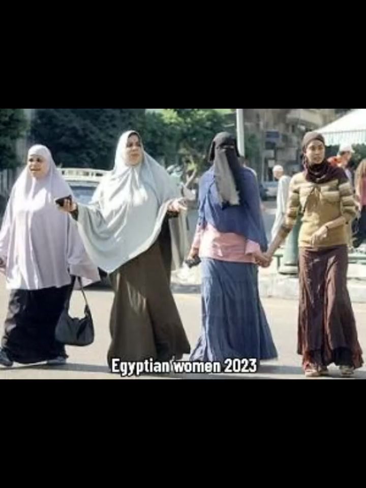 Egyptian women walking in Cairo in 2023, all wearing hijab, with one in a full face-covering niqab.