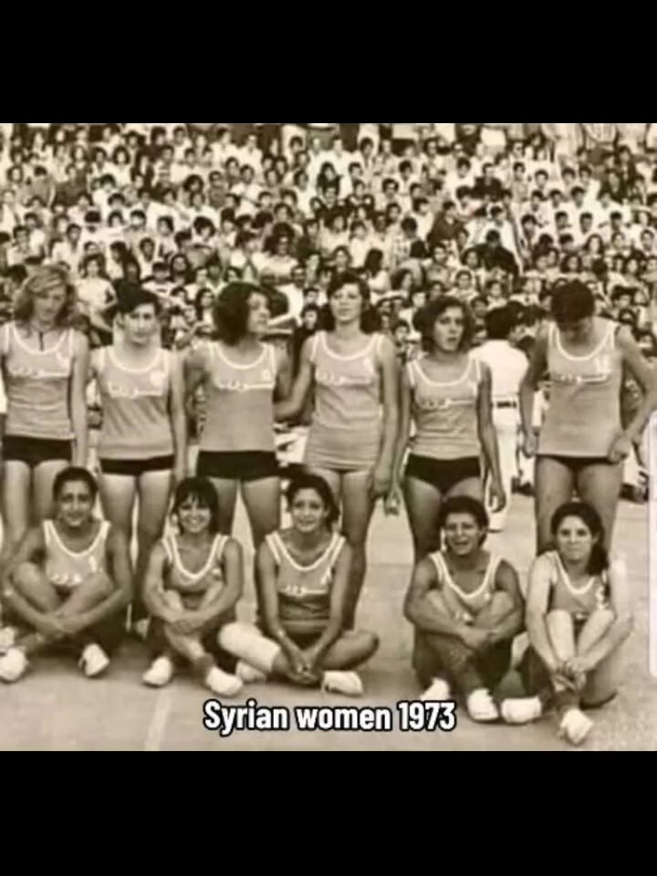 Syrian women's sports team in 1973 in athletic shorts and jerseys at a packed stadium — faces visible, hair uncovered, wearing team uniforms.